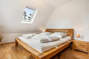 a bedroom with a bed with white sheets and a window at Haus 29 in Röbel