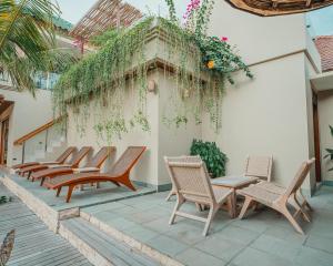 a row of chairs and tables on a patio at MJ Villa Sanur in Sanur