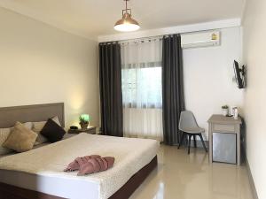 a bedroom with a bed and a desk and a window at Sunday Ayothaya Hotel in Phra Nakhon Si Ayutthaya +34 photos