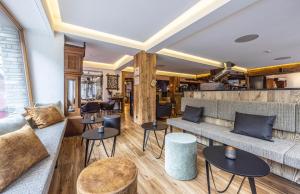 a restaurant with a couch and tables and chairs at Hotel Bristol in Zermatt +49 photos