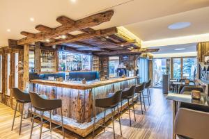 a bar in a restaurant with wooden walls and chairs at Hotel Bristol in Zermatt