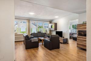 ein Wohnzimmer mit Sofa, Sesseln und Fernseher in der Unterkunft Hoffmanns in Burgkirchen an der Alz