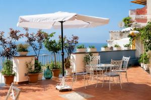 a patio with a table and chairs and an umbrella at La Terrazza del Sole a Positano in Positano