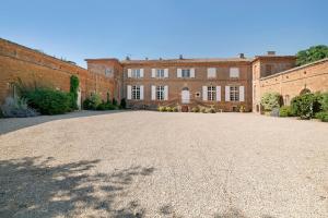 a large brick building with a large driveway at Gite Du Cerisier - Varennes in Varennes