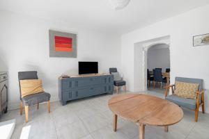 a living room with a table and chairs and a tv at Gite Du Cerisier - Varennes in Varennes