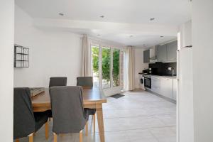 a kitchen and dining room with a wooden table and chairs at Gite Du Cerisier - Varennes in Varennes