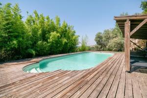 a swimming pool on a wooden deck at Gite Du Cerisier - Varennes in Varennes
