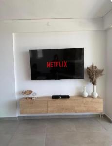 a television on a wall in a living room at Aegean Horizon Seafront Luxury Villa Plomari Garden Level in Trýgonas