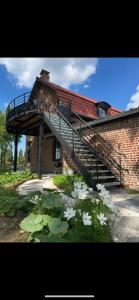 a brick building with a staircase and a bunch of white flowers at La ferme des peupliers in Estaires