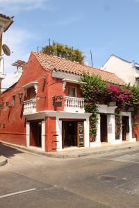a red and white building on a street with flowers at Life is Good Cartagena Hostel in Cartagena de Indias