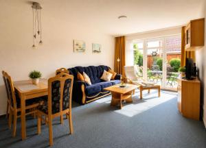a living room with a blue couch and a table at FeWo kleine Auszeit in Cuxhaven