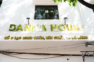 a sign on the side of a white house at Danna House Da Nang BNB in Danang