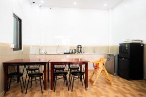a kitchen with a counter and four chairs around a table at Danna House Da Nang BNB in Danang