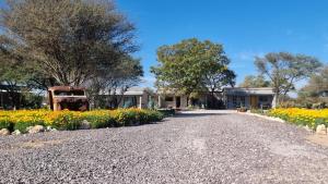 a house with a truck parked on the side of a gravel road at Maggie's Farm Stay in Khanzi