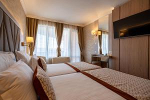 a hotel room with two beds and a television at Hissar Spa Hotel in Hisarya