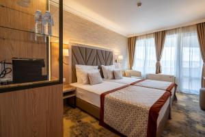 a hotel room with a bed and a television at Hissar Spa Hotel in Hisarya