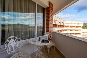 a balcony with a table and chairs and a window at Hissar Spa Hotel in Hisarya