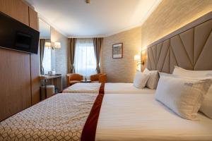 a hotel room with two beds and a chair at Hissar Spa Hotel in Hisarya +171 photos