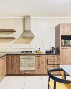 a kitchen with wooden cabinets and a stove top oven at Zion on Mayfair in Cape Town +6 photos