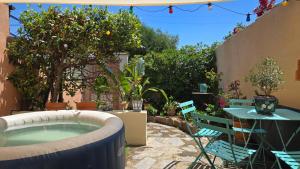 a patio with a hot tub and a table and chairs at Laure Cabasson in Bormes-les-Mimosas
