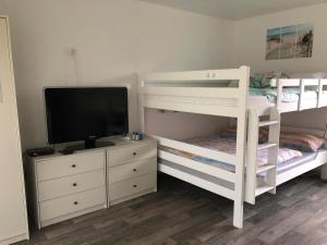 a bedroom with two bunk beds and a television at FEWO Kliff Watt Nr.4 in Cuxhaven