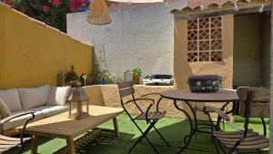 a patio with a couch and a table and chairs at Laure Cabasson in Bormes-les-Mimosas
