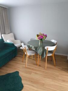a living room with a table with a vase of flowers on it at Apartament Jeziorna in Debrzno +2 photos