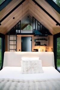 a bedroom of a house with a white bed at Sāmeland Retreat, Mirrored Glass Cabins, Swedish Lapland in Arvidsjaur