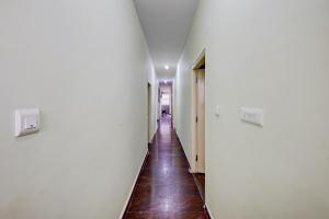 a hallway with white walls and a wooden floor at SPOT ON Ganesh in Kaglipur