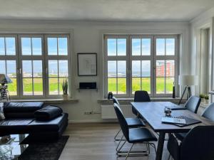 a living room with a table and chairs and windows at Am Seedeich 7 SE10 Seesicht in Cuxhaven