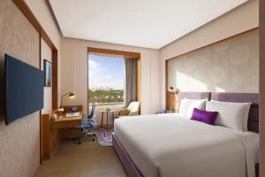 a hotel room with a large bed and a window at Vivanta Gurugram Sector 95A in Gurgaon +82 photos
