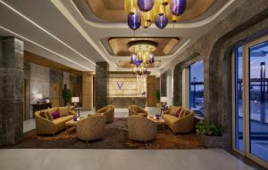 a lobby with chairs and tables and a chandelier at Vivanta Gurugram Sector 95A in Gurgaon