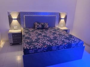 a bedroom with a purple bed with two lamps on it at Résidence keur Saloum in Thiès