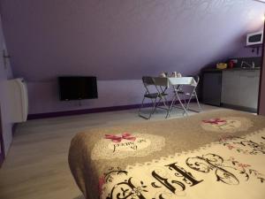 a room with a bed and a table and a tv at Les ANGES DE SAINTE ANNE in Plumergat