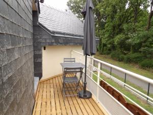 a table and an umbrella on a deck at Les ANGES DE SAINTE ANNE in Plumergat