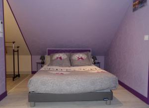 a purple bedroom with a bed with purple walls at Les ANGES DE SAINTE ANNE in Plumergat