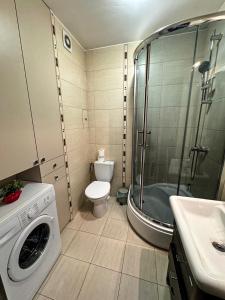 a bathroom with a washing machine and a toilet at The Third Six in Świnoujście +3 photos