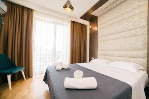 a hotel room with a bed with two towels on it at Hotel Platino Prestige in Ulcinj