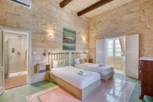 a bedroom with two beds and a walk in shower at Kikka Holiday Home in Xagħra +38 photos
