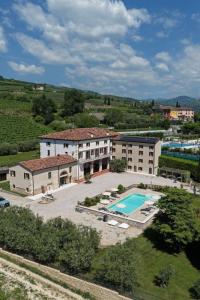an aerial view of a building with a swimming pool at VerdeOlivo 1876 - Apartments & Pool in Mezzane di Sotto