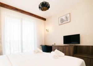 a bedroom with two beds and a flat screen tv at Hotel Platino Prestige in Ulcinj