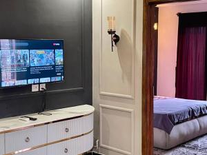 a bedroom with a tv on a wall and a bed at 2BHK Apartment Perfect for Families & Groups in Rawalpindi