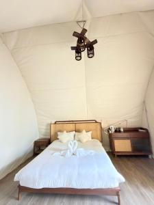 a bed in a tent with a ceiling fan at Umbrella tree เต้ทน์ in Nathon Bay