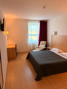 a bedroom with a bed and a chair and a window at Hotel del Vino in Cariñena +11 photos