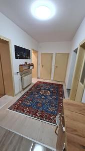 an empty room with a rug on the floor at Sabina Apartmani in Tuzla +7 photos