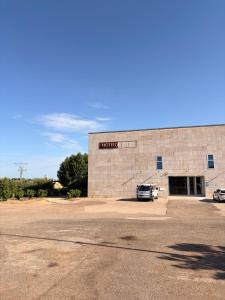 a building with a car parked in a parking lot at Hotel del Vino in Cariñena