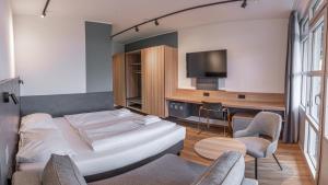 a hotel room with a bed and a table and chairs at Sportschule Oberhaching in Oberhaching