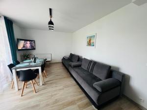 a living room with a black couch and a table at Łebska ostoja in Żarnowska