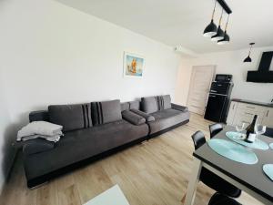 a living room with a black couch and a table at Łebska ostoja in Żarnowska