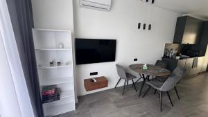 a dining room with a table and a television at Bamboo Beach 358 in Ts'ikhisdziri